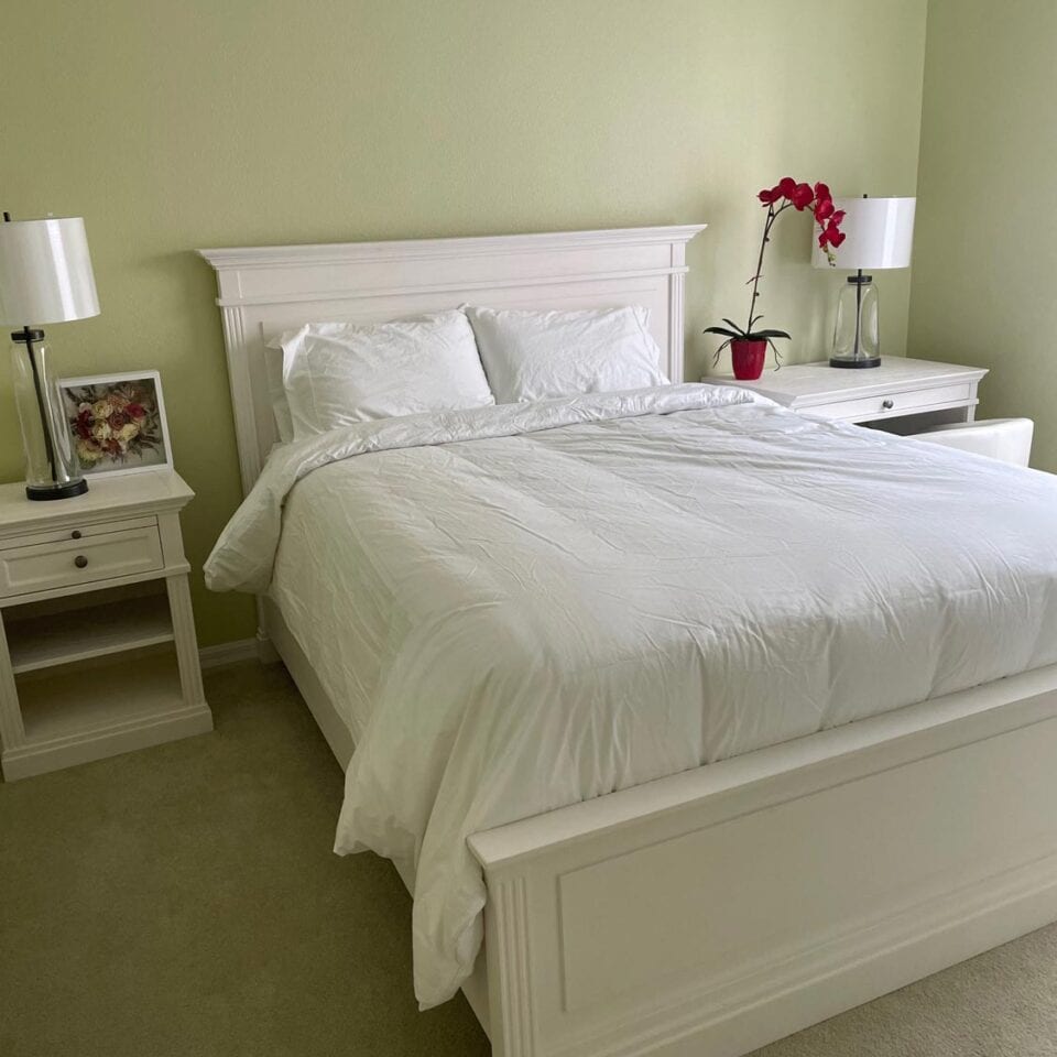 A neatly made bed with crisp white linens offers a serene and inviting space for Postpartum Recovery in Tampa, Florida.